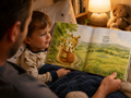 father and young child rreading bee-lieve and the shy snail picture book at bedtime